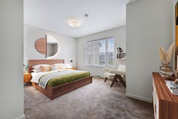 A bedroom with gray walls and a large window
